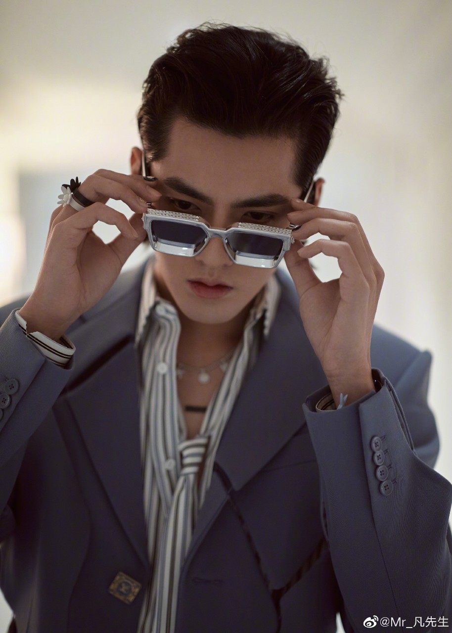 吴亦凡身着2020秋冬男装系列灰蓝色镂空剪裁西服,搭配同款长裤,耳边与